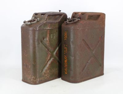 two old metal cans are sitting next to each other on a white surface
