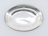 a silver plate on a white surface with a silver handle
