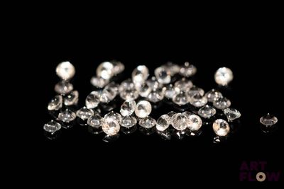 a close up of a bunch of diamonds on a black surface