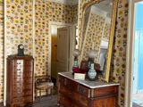 a dresser and a mirror in a room with sunflowers on the walls
