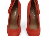 une paire de chaussures en daim rouge ornées d'un nœud au talon