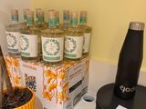 many cups and a bottle on the counter next to each other