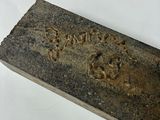 a piece of stone with writing on it on a white surface