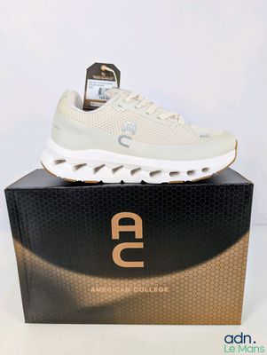 Il y a une basket blanche posée sur la boîte à chaussures.