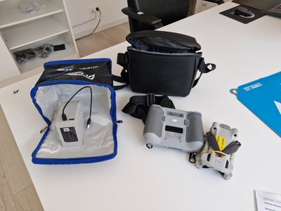 une table blanche sur laquelle se trouvent un sac et un appareil photo