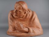 a statue of an old man holding his hands together