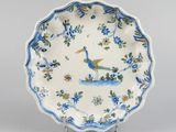 blue and white plate with a peacock and flowers on it