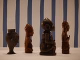four wooden figurines sitting on a white table