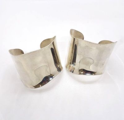 une paire de bracelets manchette en argent sur fond blanc