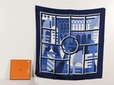 une écharpe bleue et blanche accrochée au mur à côté d'une boîte orange