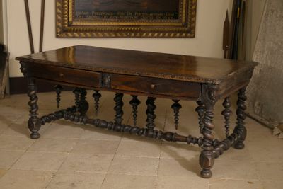une table avec un plateau en bois dans une pièce où est accroché un tableau au mur