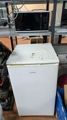 un réfrigérateur blanc et un micro-ondes dans une pièce
