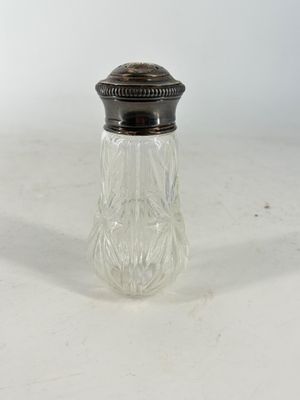 un ensemble de sel et de poivre en verre ancien posé sur une table blanche