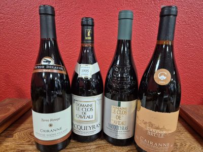 several bottles of wine are lined up on a wooden table