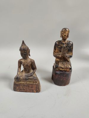 two statues of a man and a woman sitting on wooden blocks