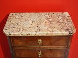 a marble top on a wooden dresser against a red wall