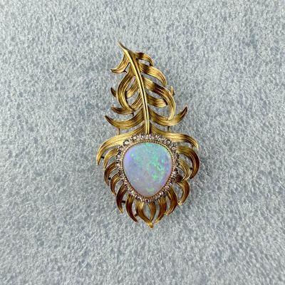 an oplite and diamond broochle on a white cloth