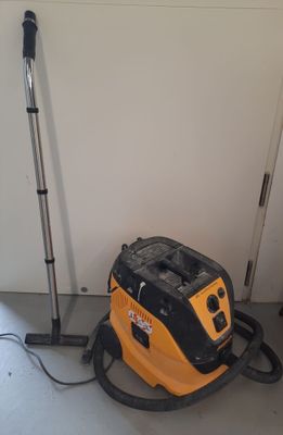a vacuum that is sitting on the floor next to a pole