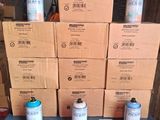 plusieurs pots de peinture posés sur une table, à côté d'une pile de cartons