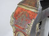 a red and gold clock sitting on top of a table