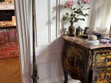 a vase of flowers on a table next to a broom