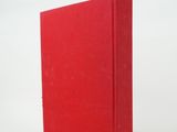 the red book is sitting on a white surface with a white background