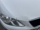 a white car that has been damaged and is parked in a parking lot