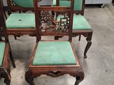 four chairs with green cushions are sitting on a concrete floor