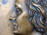 a close up of a statue of a woman with curly hair