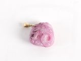 un objet rose en forme de cœur posé sur une surface blanche