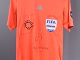 a close up of a shirt with a soccer jersey on a hanger