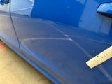a sticker on the side of a blue car that has a sticker on it