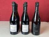 quatre bouteilles de vin sont alignées sur un comptoir