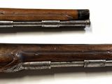 pair of antique flints with wooden handles on a white surface