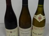 three bottles of wine sitting on a table next to each other