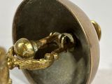 a small brass object with a bird on top of it