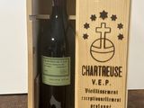une caisse en bois contenant une bouteille de vin, posée sur une table