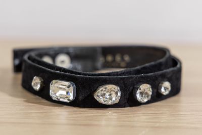 black leather dog collar with crystal studs on a wooden table