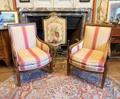 une paire de fauteuils rayés devant une cheminée dans un salon