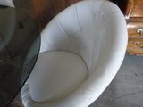 a white chair that is sitting next to a table
