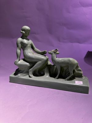 statue d'une femme assise sur un rocher avec une chèvre, sur fond violet