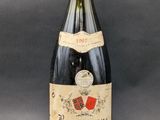 an old bottle of wine sitting on top of a table