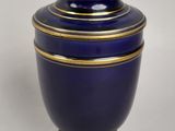 un vase bleu bordé d'or sur fond blanc