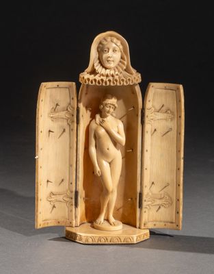 figurine en ivoire sculpté représentant une femme tenant un bébé dans une boîte en bois ouverte