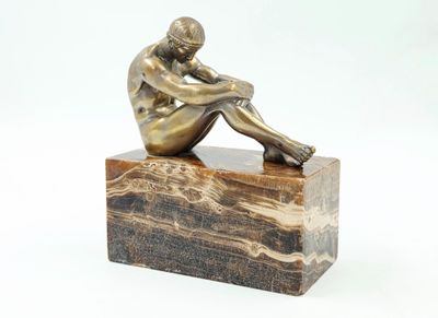 statue d'un homme assis sur un bloc de marbre, sur fond blanc