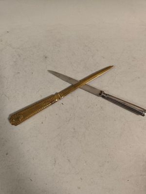 a knife and a pen on a table next to each other