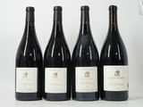 quatre bouteilles de vin sont alignées sur une table