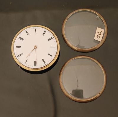 une horloge posée sur une table à côté d'un miroir