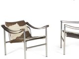 pair of lounge chairs with cow hide and metal frame