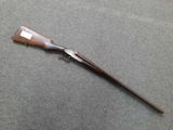 a rifle with a wooden handle on a gray surface